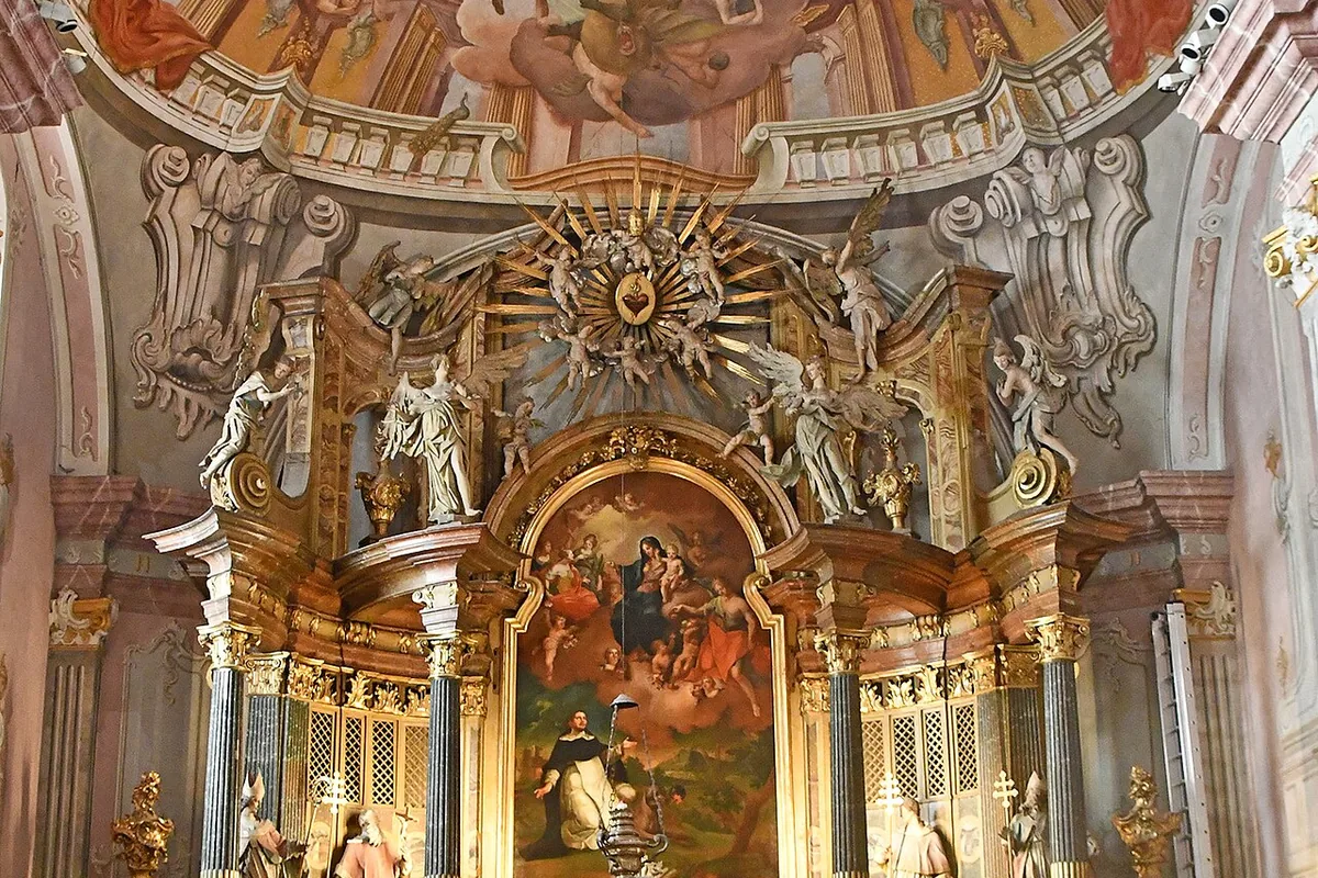 A gilded Baroque altar in a Budapest church, framed by twisted columns and surmounted by a golden sunburst